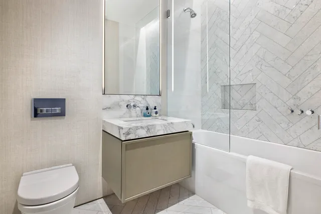 a bathroom with a granite countertop sink a toilet and bathtub