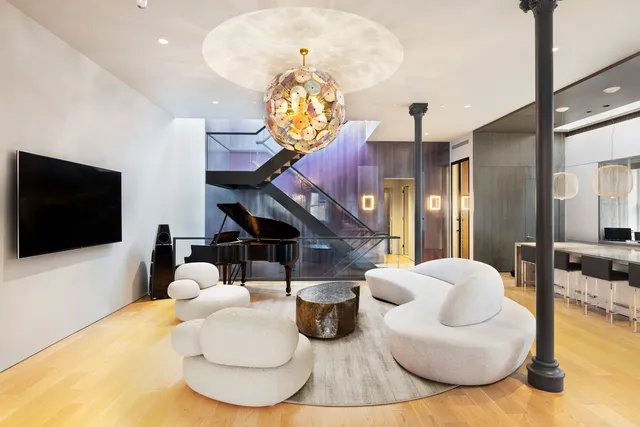 a living room with furniture a chandelier and a flat screen tv