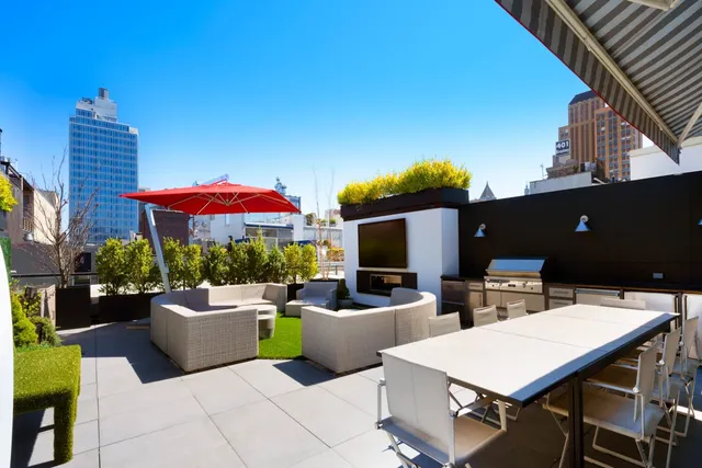 a dining room with wooden floor and kitchen view