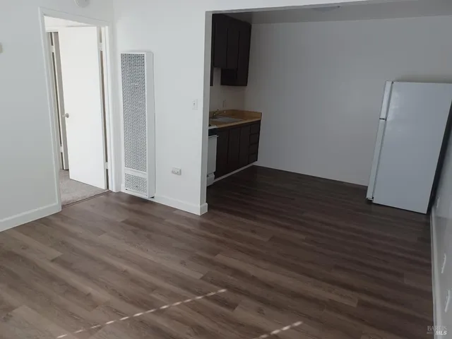an empty room with wooden floor and cabinet
