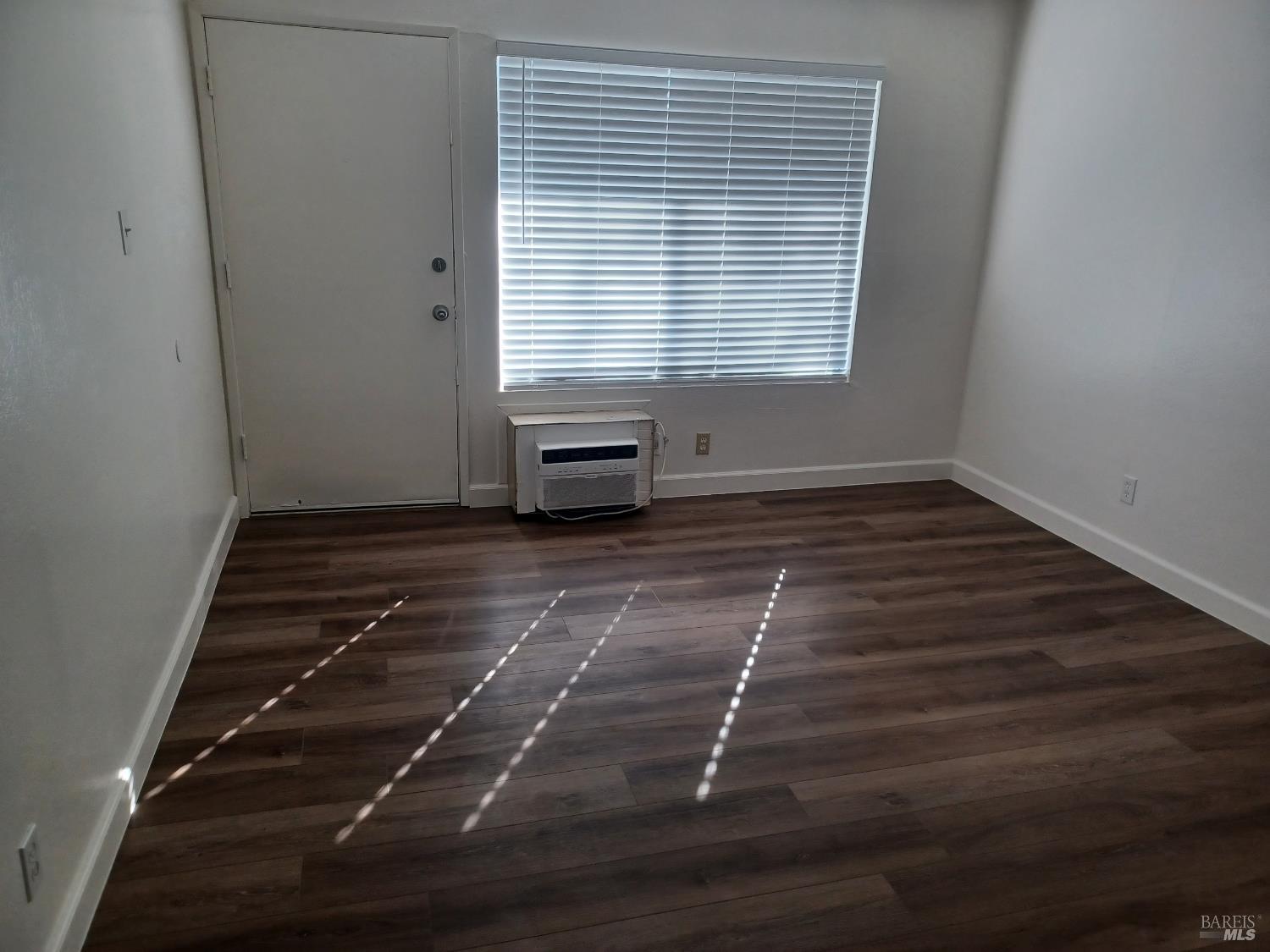 1955 Grande Circle, Unit O Fairfield, CA 94533 - Photo 7 of 7 a view of an empty room with wooden floor and a window