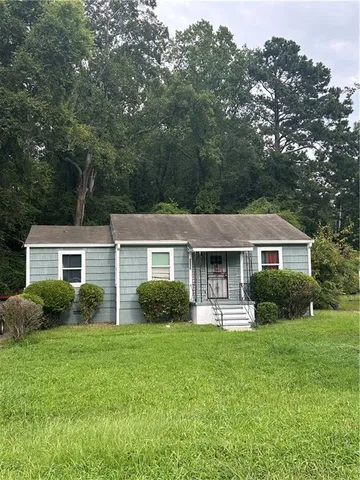 a front view of a house with a yard and green space