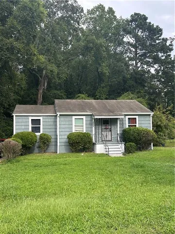 a front view of a house with a yard and green space