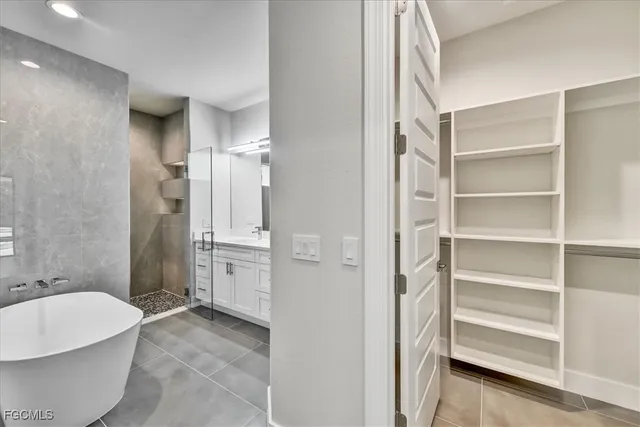 an empty room with chandelier fan and windows