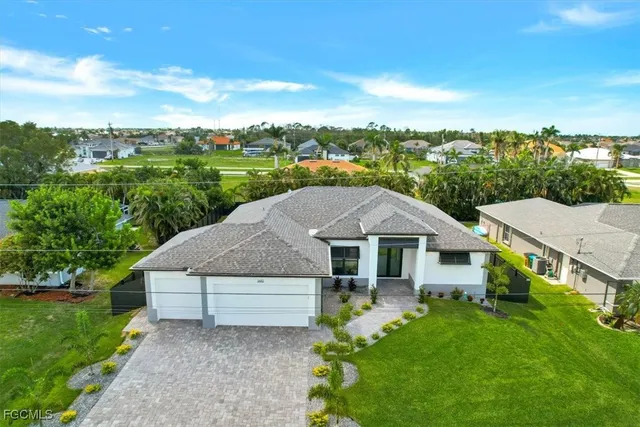 an aerial view of a house with swimming pool and garden