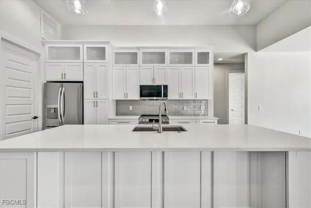 a kitchen with stainless steel appliances a stove refrigerator sink and cabinets