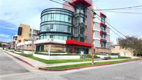 a front view of multi story residential apartment building with yard