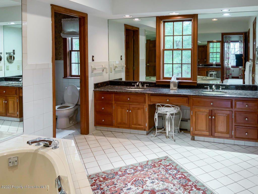 715 Lantern Hill Road Shavertown, PA 18708 - Photo 23 of 38 a spacious bathroom with a granite countertop sink and a mirror