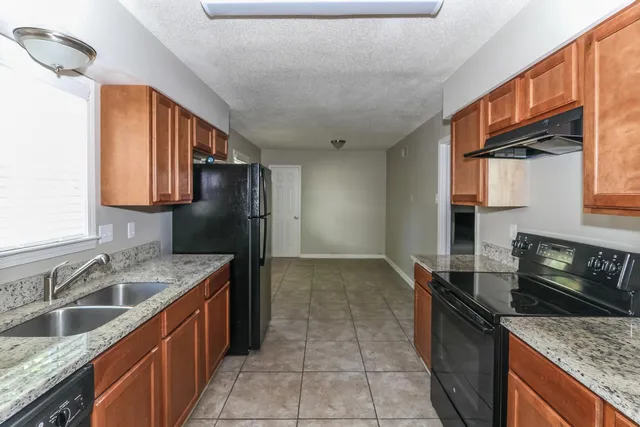 a kitchen that has a sink a stove and a oven