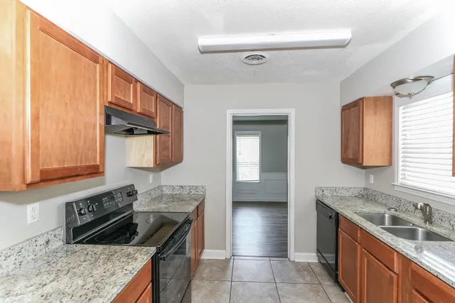 a kitchen with a stove sink and cabinets