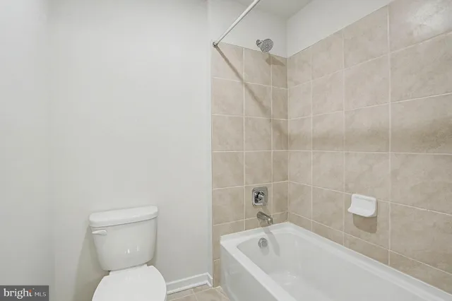 a white toilet sitting next to a bath tub