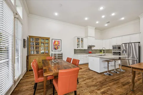 a open dining room with stainless steel appliances granite countertop a dining table chair and a refrigerator