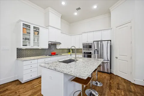 a kitchen with granite countertop a table chairs microwave and refrigerator