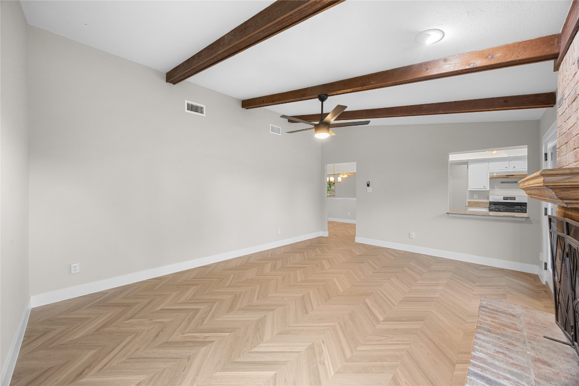 11714 Buckingham Road Austin, TX 78759 - Photo 14 of 35 Great room featuring a fireplace, ceiling fan, and beamed ceiling