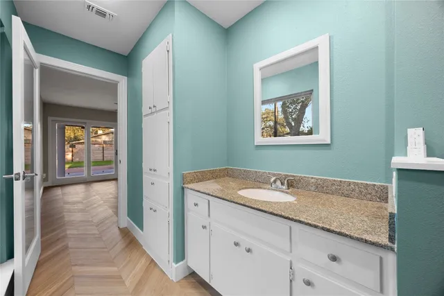 a bathroom with a granite countertop sink and a mirror