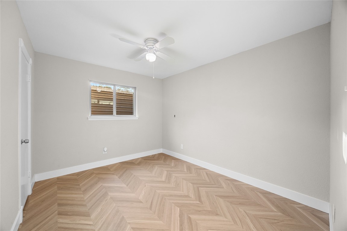 11714 Buckingham Road Austin, TX 78759 - Photo 25 of 35 Secondary bedroom with tall baseboards LVP on herringbone pattern and a ceiling fan