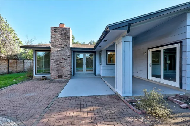 a view of a house with a backyard and a tree