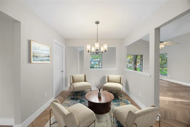 a living room with furniture a chandelier and a window