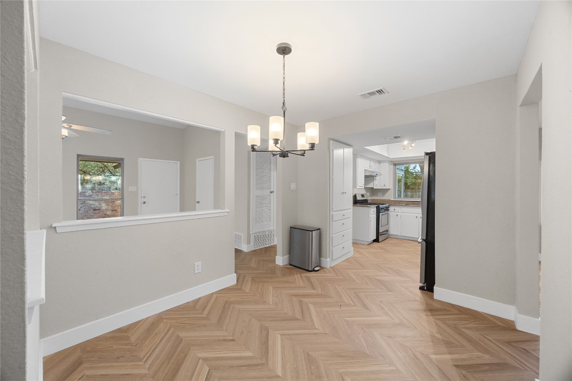 11714 Buckingham Road Austin, TX 78759 - Photo 9 of 35 Dining or flexible area featuring a chandelier and LVP on herringbone / chevron pattern.