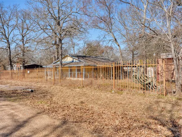 a view of a yard with wooden fence