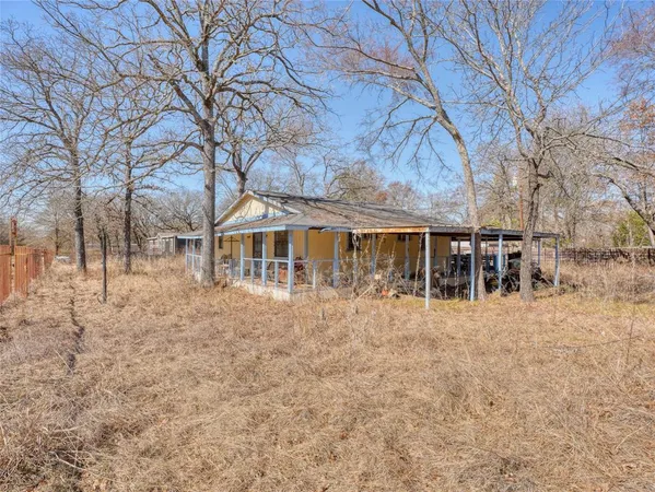 a view of house with yard and sitting area