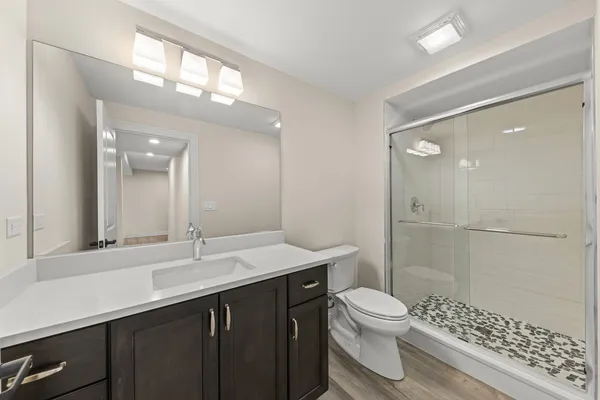 a bathroom with a sink a toilet a shower and a mirror