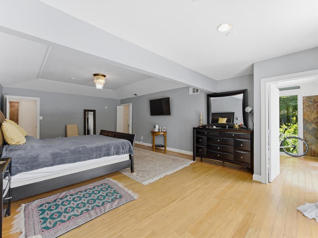 6160 Spring Valley Road Dallas, TX 75240 - Photo 26 of 40 Spacious room featuring wood-finish flooring, light gray wall paint, and a tray ceiling with a contemporary chandelier
