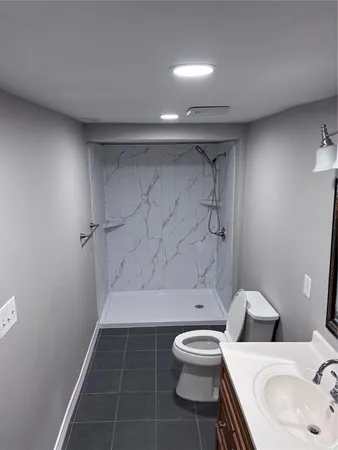 a bathroom with a sink a toilet and shower