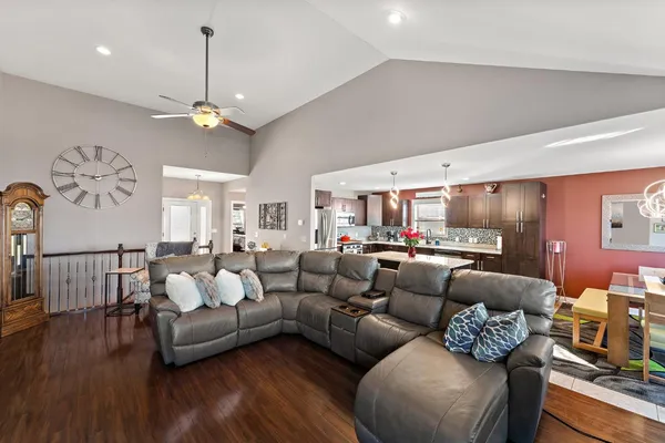 a living room with furniture kitchen view and a wooden floor
