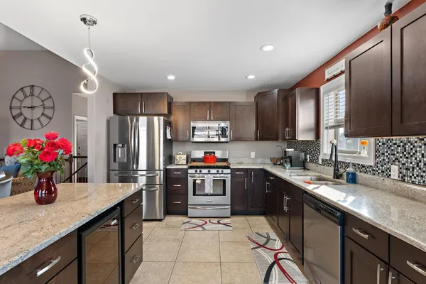a kitchen with granite countertop a sink stainless steel appliances and cabinets