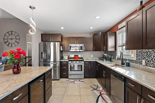 a kitchen with granite countertop a sink stainless steel appliances and cabinets