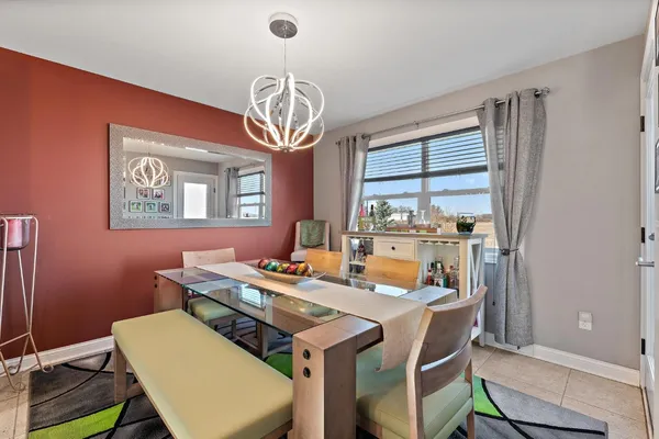 a view of a dining room with furniture a chandelier and wooden floor