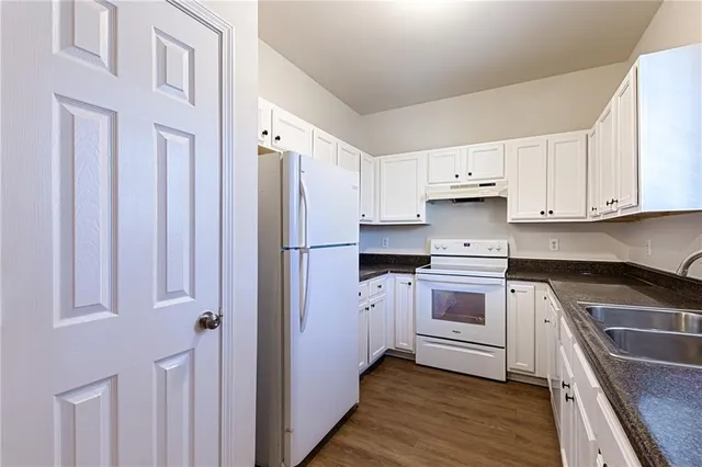 a kitchen with white cabinets and white appliances