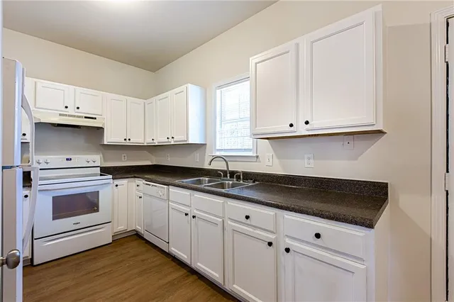 a kitchen with granite countertop white cabinets and a stove