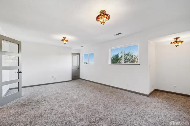 a bedroom with a bed and a large window with wooden floor