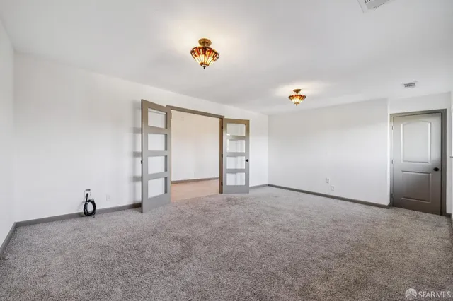 an empty room with windows fireplace and wooden floor