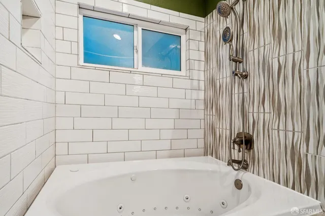 an empty room with wooden floor closet and windows
