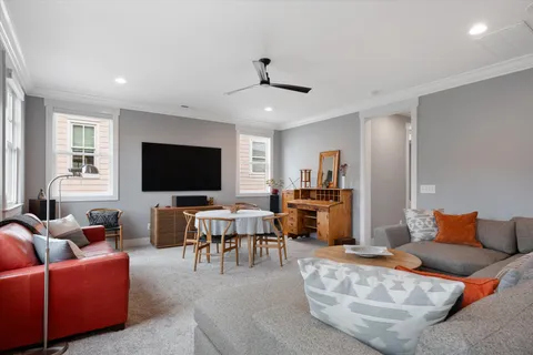 a living room with furniture kitchen and a flat screen tv