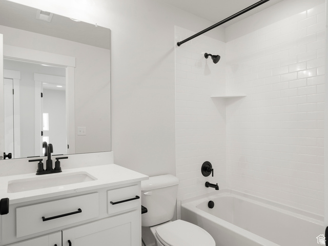 1711 West Canyon Rim Road North Lehi, UT 84048 - Photo 15 of 31 Bathroom featuring a white subway tile shower surround with a built-in shelf, white vanity with an integrated sink, matte black fixtures, and a frameless mirror