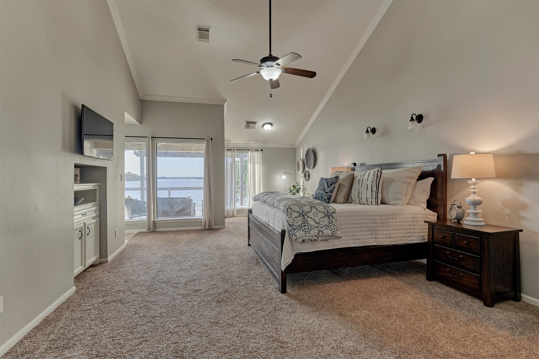 157 Capetown Way Conroe, TX 77356 - Photo 16 of 32 a spacious bedroom with a bed a dresser and a chandelier
