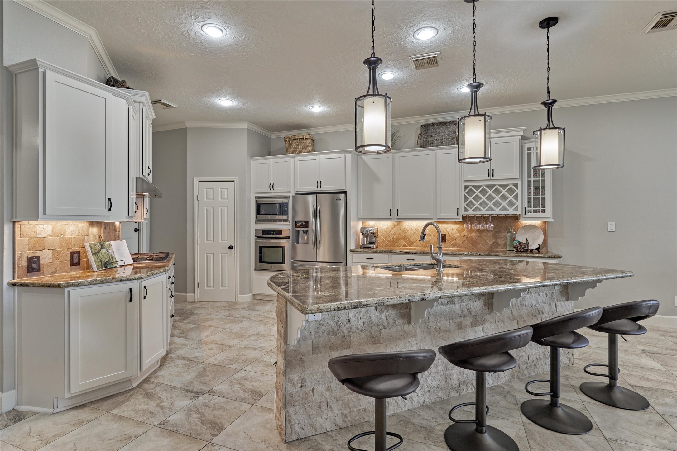 157 Capetown Way Conroe, TX 77356 - Photo 8 of 32 a kitchen with kitchen island granite countertop a table and chairs in it