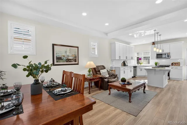 a living room with furniture kitchen view and a potted plant