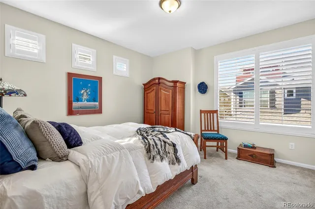 a bedroom with a bed and a dresser next to a window