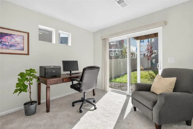 a view of a livingroom with workspace and a window