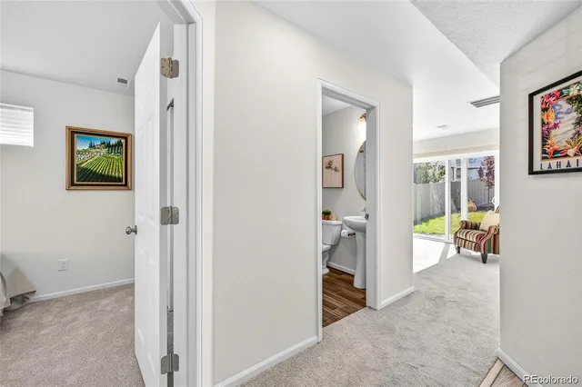 a view of a hallway view with wooden floor and a living room
