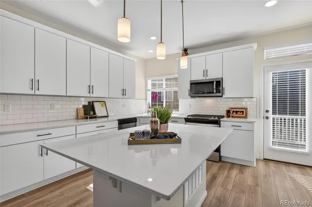 a kitchen with kitchen island a white counter top space cabinets and stainless steel appliances