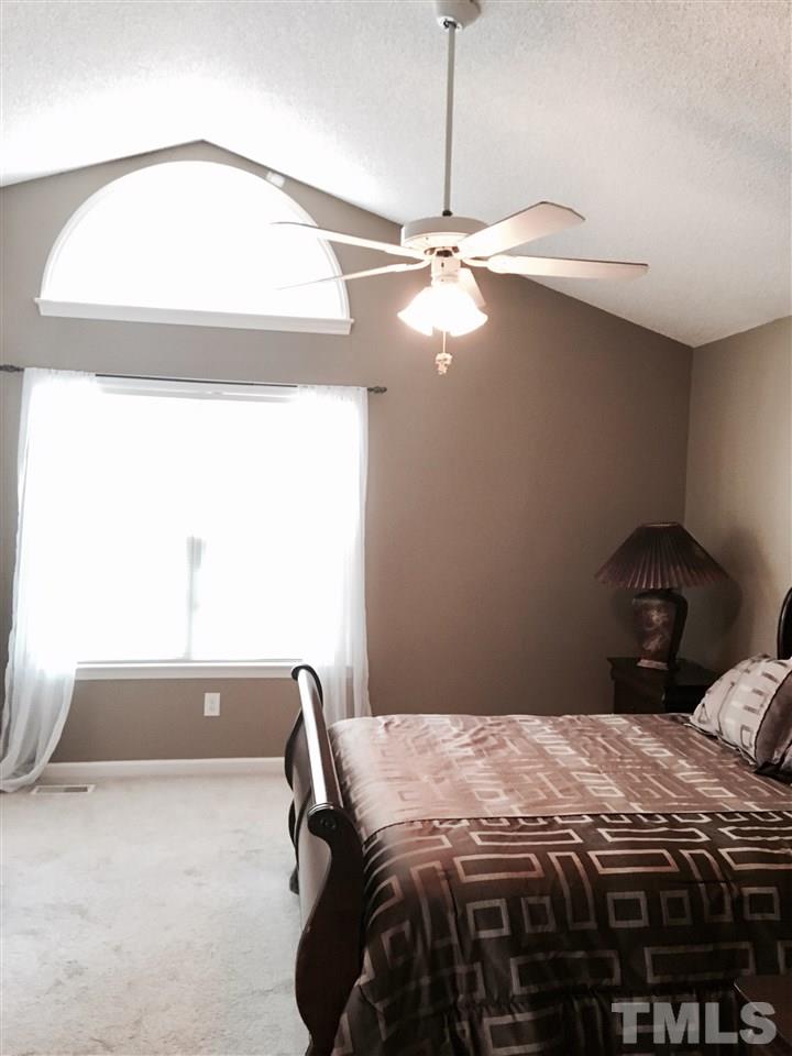 169 South Ridge Drive Garner, NC 27529 - Photo 13 of 20 a bedroom with a bed and a chandelier