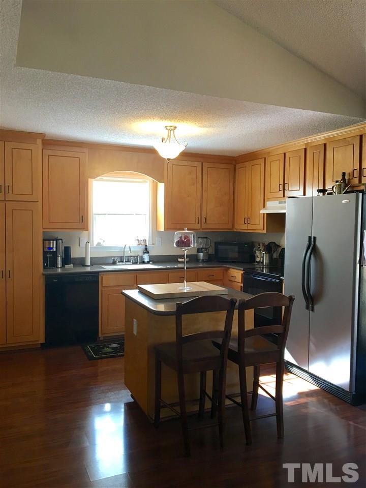 169 South Ridge Drive Garner, NC 27529 - Photo 20 of 20 a kitchen with granite countertop a refrigerator a sink a stove a dining table and chairs