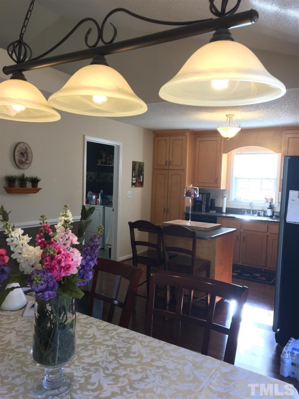 169 South Ridge Drive Garner, NC 27529 - Photo 5 of 20 a kitchen with a chandelier stainless steel appliances and dining table
