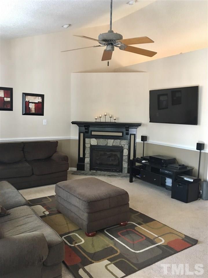 169 South Ridge Drive Garner, NC 27529 - Photo 8 of 20 a living room with furniture a flat screen tv and a fireplace